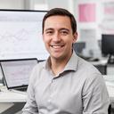 Consultant smiling in a modern office with a laptop and project timeline on screen