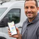 Lancaster HVAC owner standing beside a service van and checking schedules on a phone
